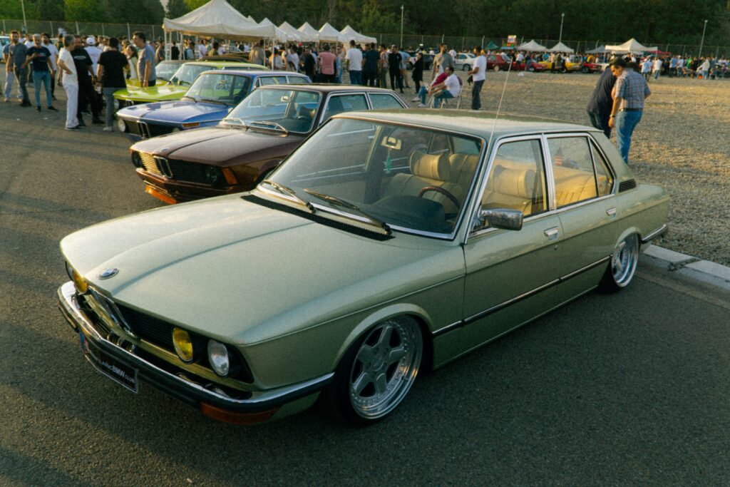 A vintage light green BMW sedan parked outdoors.